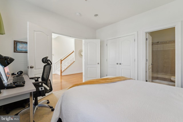 bedroom featuring a closet, light wood-type flooring, and connected bathroom