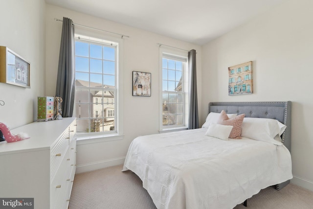 bedroom with light carpet and baseboards