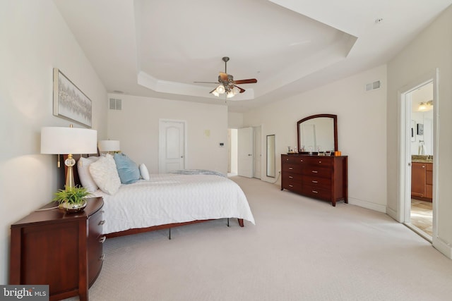 bedroom featuring light carpet, ceiling fan, a raised ceiling, and visible vents