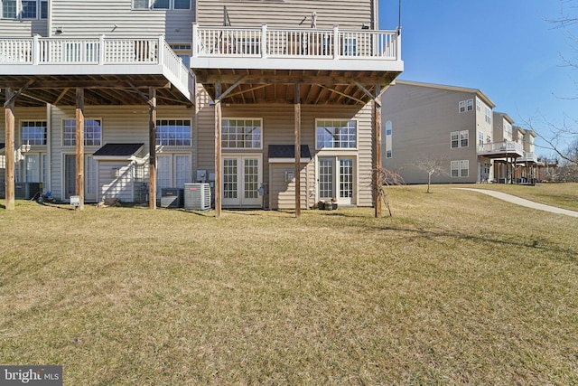 back of house with cooling unit and a lawn