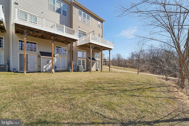 back of house featuring central AC unit and a lawn