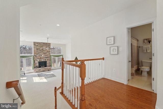 corridor featuring recessed lighting, baseboards, an upstairs landing, and wood finished floors