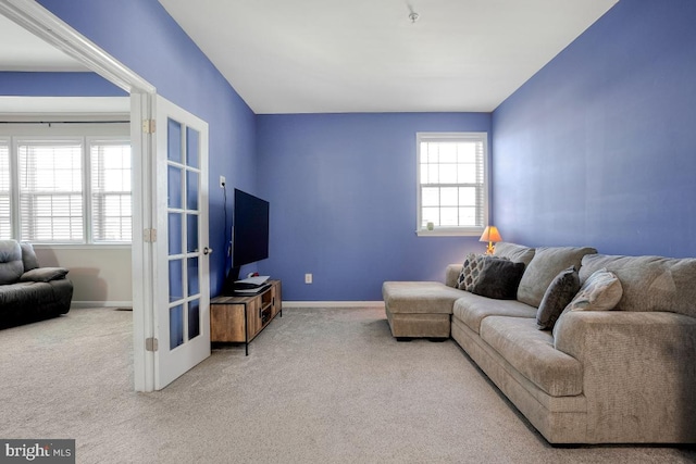 living area with light carpet and baseboards