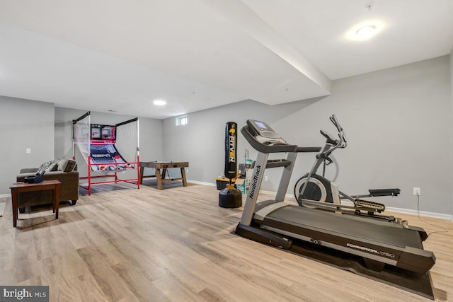 exercise area featuring light wood-type flooring and baseboards