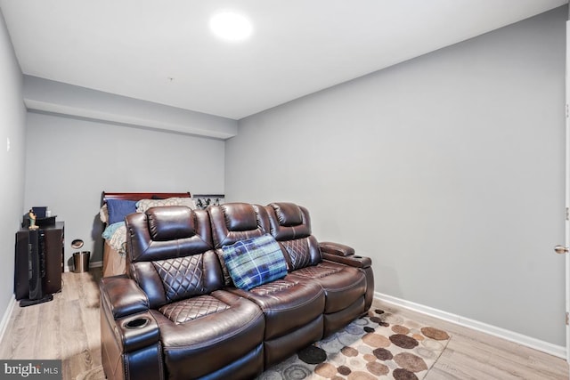 home theater featuring light wood-type flooring and baseboards