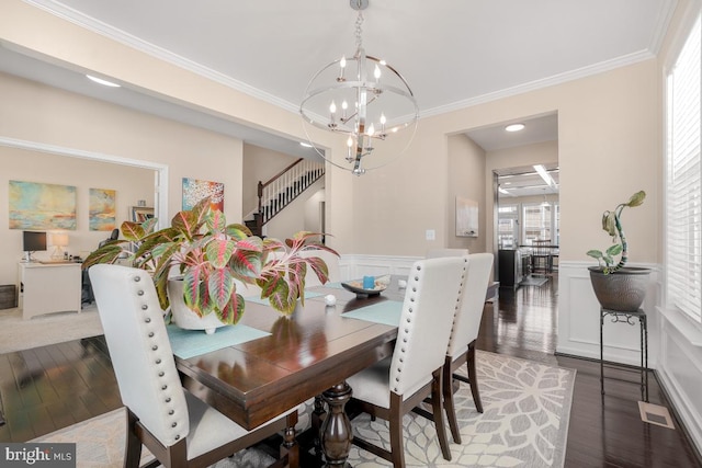 dining room featuring dark wood-style flooring, wainscoting, and visible vents