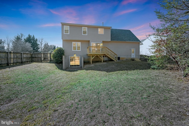 back of house with a fenced backyard, stairway, a wooden deck, and a yard