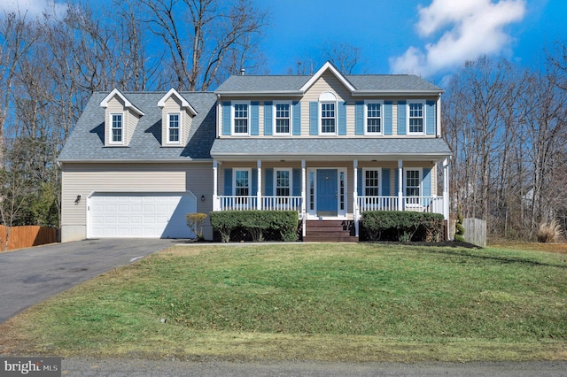 colonial house featuring roof with shingles, a porch, an attached garage, a front yard, and driveway