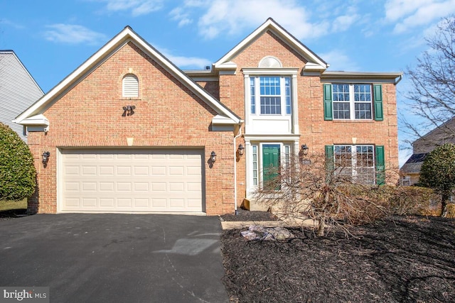 view of front of home featuring aphalt driveway, brick siding, and an attached garage