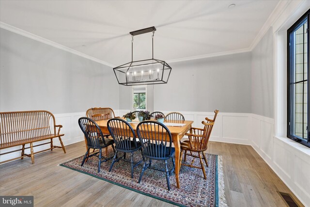 dining room featuring visible vents, a wainscoted wall, wood finished floors, and crown molding