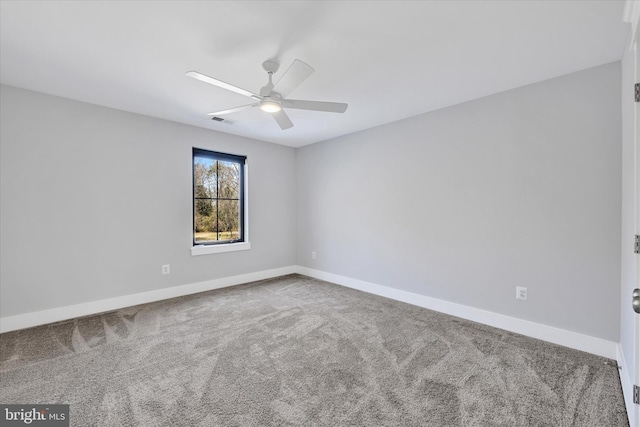 carpeted spare room featuring visible vents, baseboards, and ceiling fan