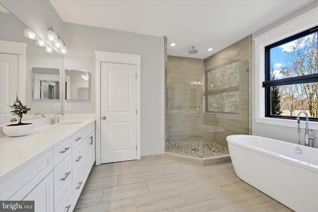 full bathroom featuring a soaking tub, vanity, recessed lighting, and a shower stall