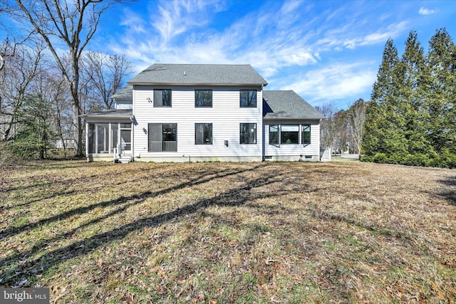 rear view of house featuring a yard and a sunroom