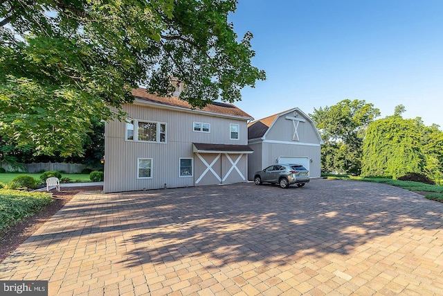 view of front facade featuring a garage, decorative driveway, and fence