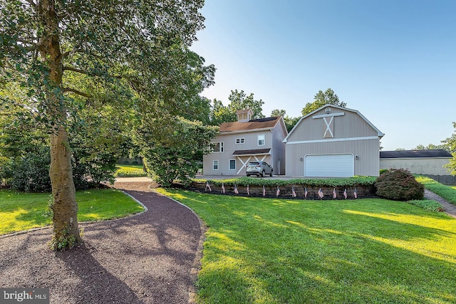 view of front of home featuring a garage, a front lawn, and an outdoor structure