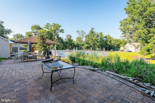 view of patio / terrace with a fenced in pool, fence, and a gazebo