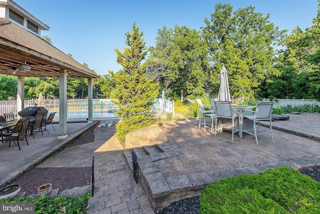 view of patio featuring outdoor dining area, fence, and a fenced in pool