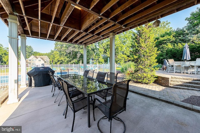 view of patio with outdoor dining area, area for grilling, and fence