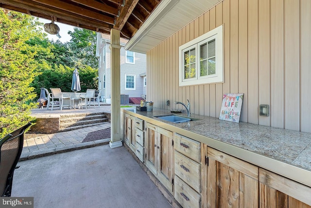 view of patio / terrace featuring outdoor dining area, area for grilling, and a sink