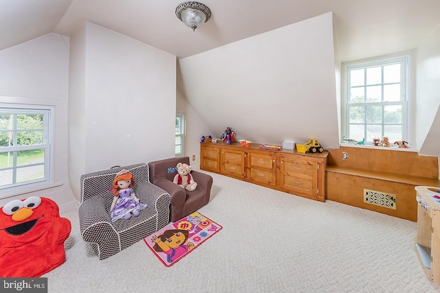 playroom featuring light colored carpet, lofted ceiling, and visible vents