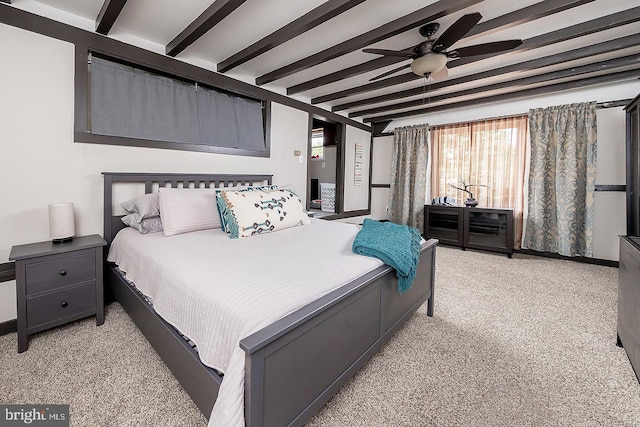 bedroom with beam ceiling and light colored carpet