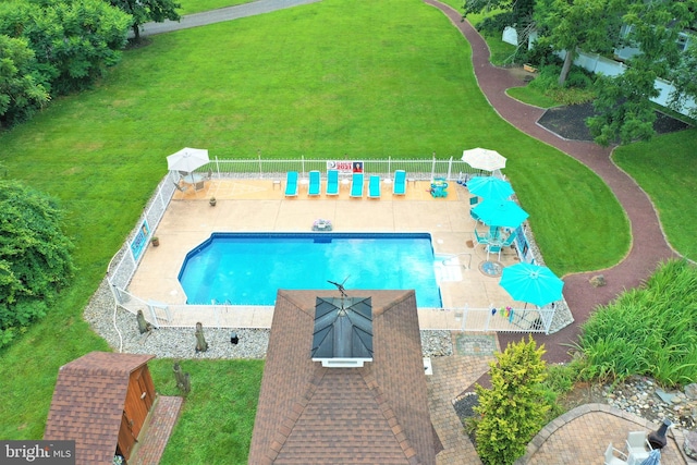 pool featuring fence, a patio, and a yard