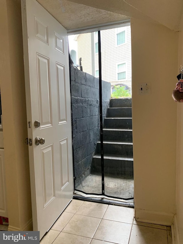 stairs featuring a textured ceiling and tile patterned floors