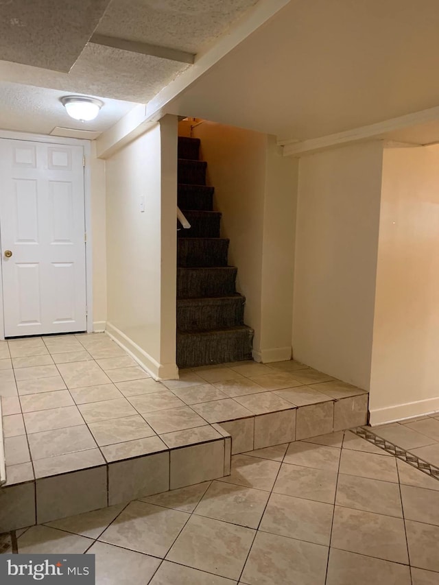 interior space featuring tile patterned flooring and baseboards