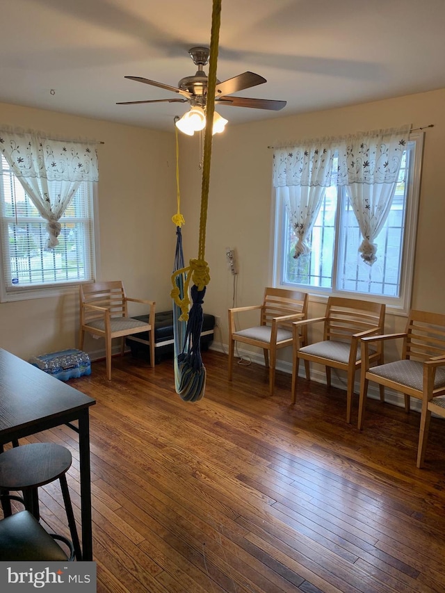 sitting room with a ceiling fan and dark wood-style flooring