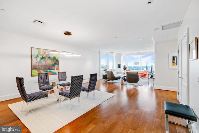 dining room with visible vents, light wood-style flooring, and baseboards