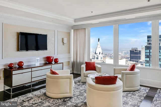 living area with plenty of natural light, a view of city, dark wood-style flooring, and crown molding