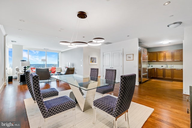 dining area with recessed lighting, visible vents, baseboards, light wood finished floors, and a wall of windows