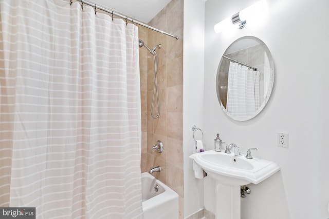 bathroom featuring a sink and shower / bath combo with shower curtain