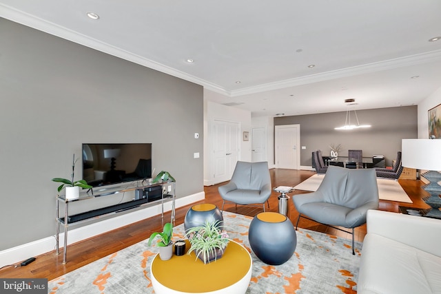 living area with ornamental molding, recessed lighting, wood finished floors, and baseboards