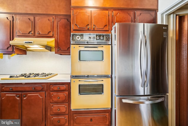 kitchen with white appliances, light countertops, and under cabinet range hood