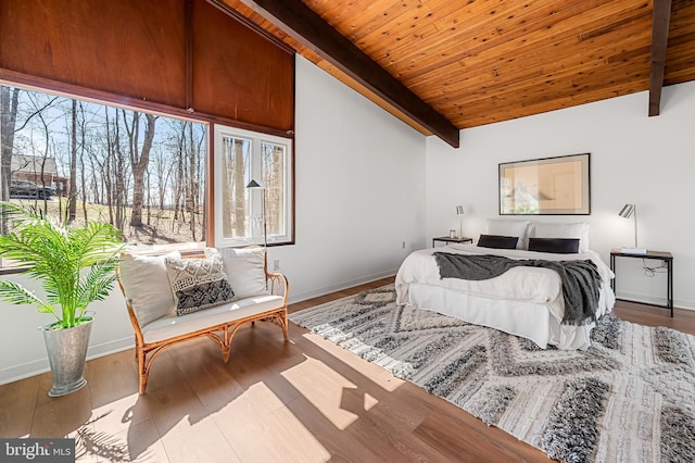 bedroom featuring lofted ceiling with beams, wood finished floors, baseboards, and wooden ceiling