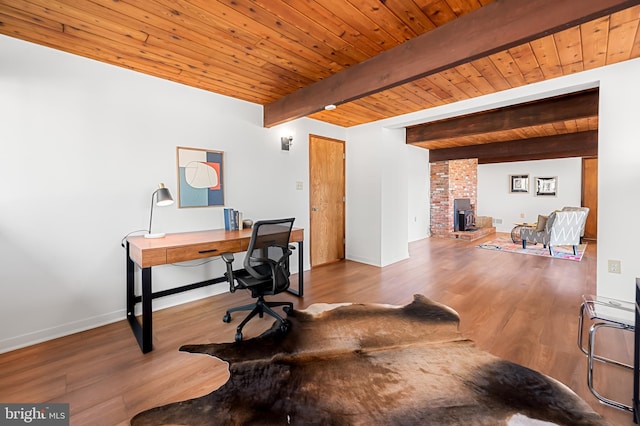 office with baseboards, wood finished floors, beam ceiling, and wooden ceiling