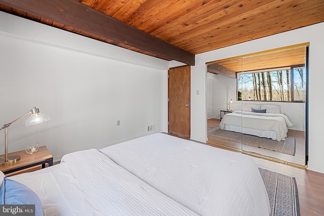 bedroom featuring beamed ceiling, wooden ceiling, visible vents, and wood finished floors