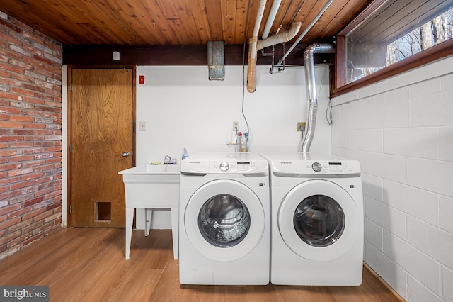 washroom with wood finished floors, brick wall, separate washer and dryer, and wooden ceiling