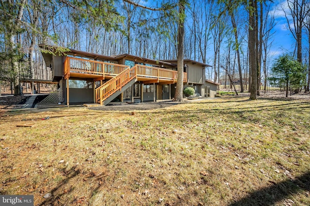 back of house featuring stairs, a deck, and a lawn