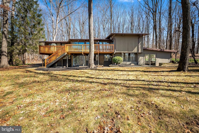 back of property featuring a wooden deck, a yard, and stairs