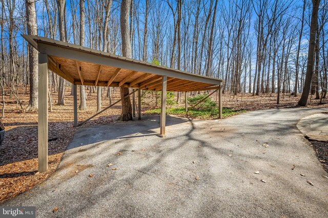 view of patio featuring aphalt driveway and a carport