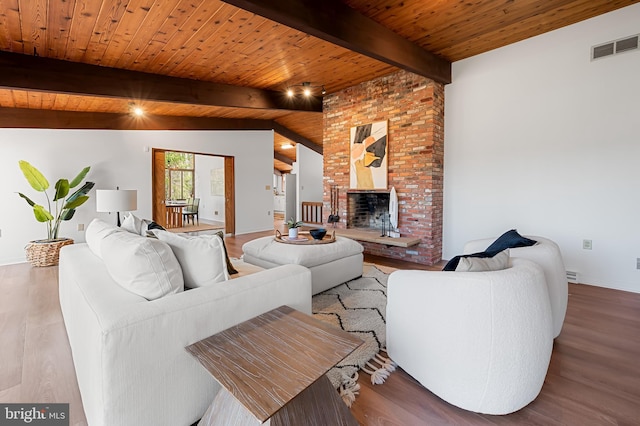 living room featuring wooden ceiling, a brick fireplace, wood finished floors, and visible vents