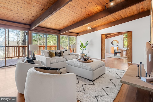 living room with baseboards, wood finished floors, wooden ceiling, and vaulted ceiling with beams