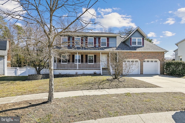 view of front of home featuring brick siding, a porch, concrete driveway, a front yard, and an attached garage