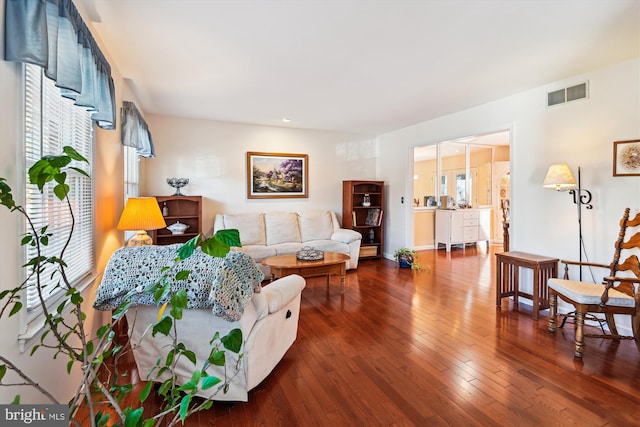 living area featuring hardwood / wood-style floors, a healthy amount of sunlight, and visible vents