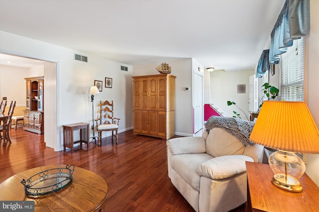 living area featuring wood finished floors, visible vents, and baseboards