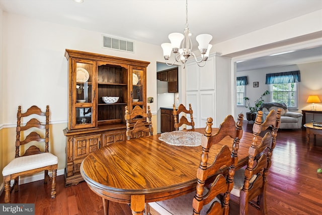 dining area with a notable chandelier, visible vents, and dark wood-style flooring