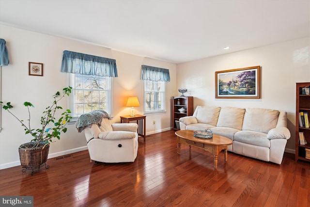 living room with visible vents, baseboards, and hardwood / wood-style flooring