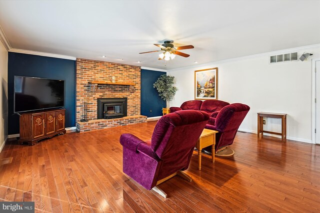 living area featuring visible vents, baseboards, hardwood / wood-style floors, and crown molding